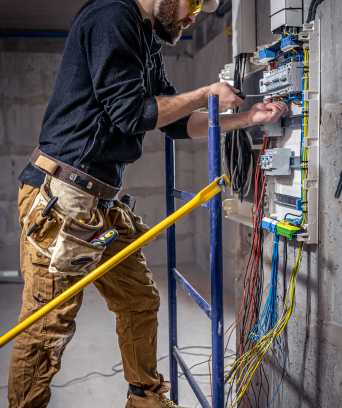 male-electrician-works-switchboard-with-electrical-connecting-cable 1 male-electrician-works-switchboard-with-electrical-connecting-cable 1